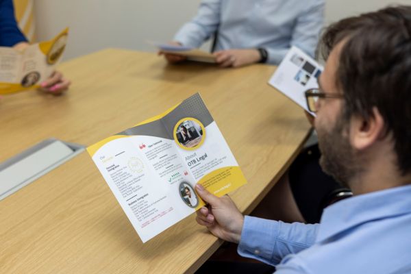 Solicitor at desking reading a leaflet about Global Talent Visa and s3C Leave